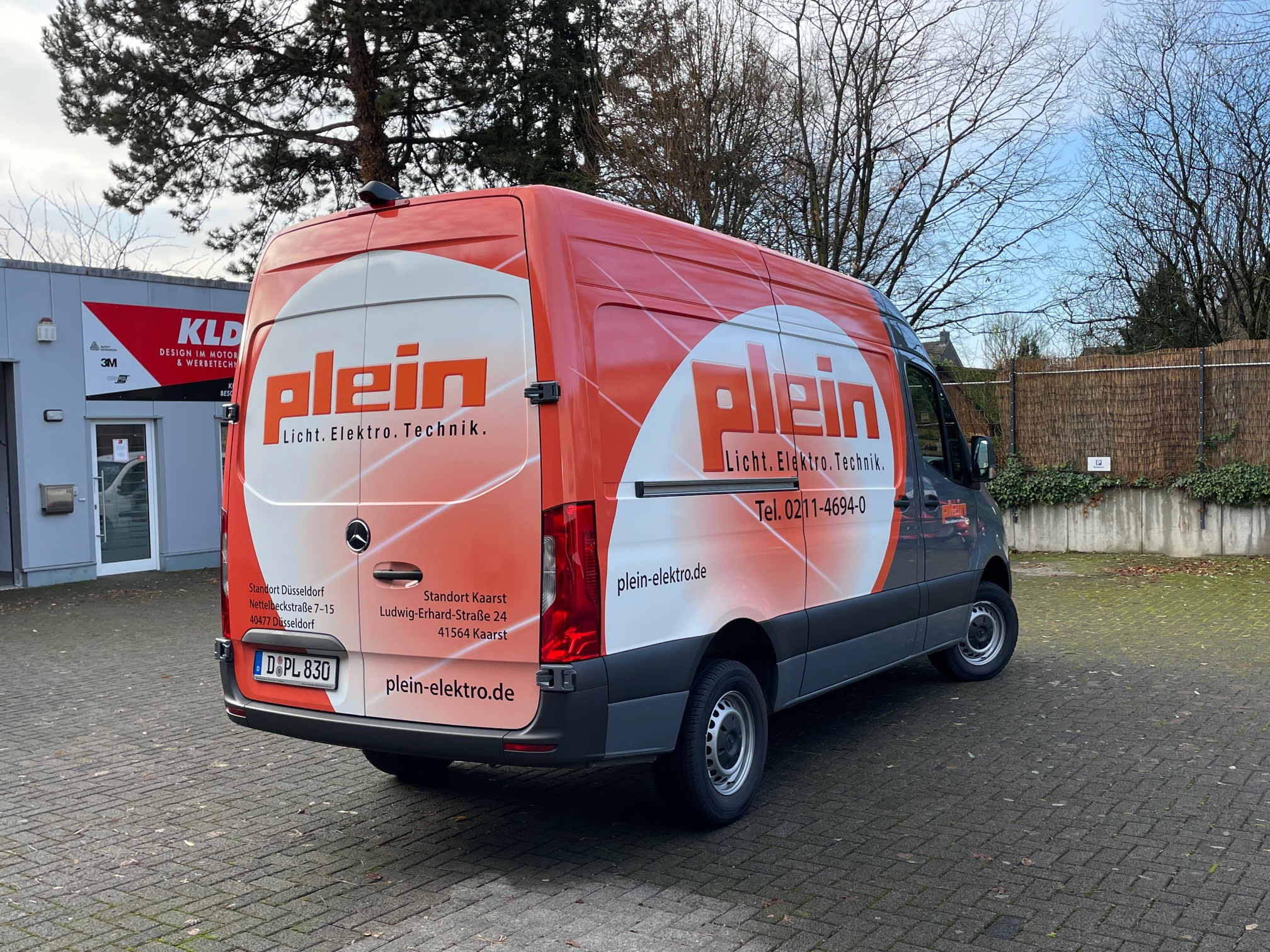 Roter und weißer Mercedes Sprinter mit Werbung der Firma 'Plein Licht. Elektro. Technik.' und Standorten in Düsseldorf und Kaarst.